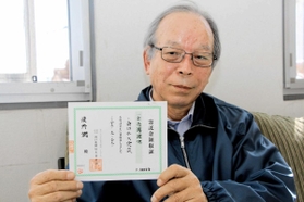 東日本大震災の発生直後に初めて寄付したときの領収証を手にする最所潤さん＝神戸新聞明石総局