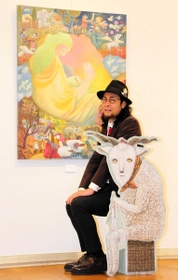 展示会に出品したたなかしんさん。原画をじかに見ると、絵の具に砂を混ぜる画風のユニークさが伝わってくる＝明石市立文化博物館