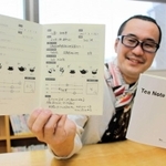 製作したティーノートを開き、自らが書き込んだページを見せる林史剛さん＝明石市内
