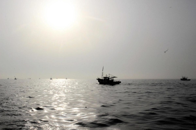海の底の砂をかき混ぜる桁を引き、海域を何度も往復する漁船＝９日午前６時２６分、明石市沖、鹿ノ瀬