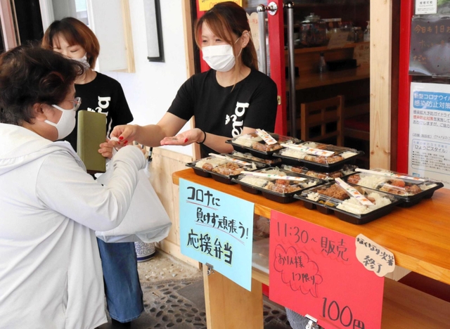 「コロナに負けるな」と１００円の弁当の販売を始めた居酒屋の高見奈緒美店長＝明石市本町１
