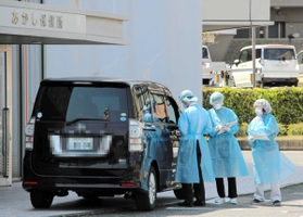 ドライブスルー方式で新型コロナウイルスの感染者を診察するあかし保健所職員（画像の一部を加工しています）＝明石市大久保町ゆりのき通１