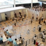 あかし市民広場の集団接種会場。４ブースのいずれかで接種した後、右奥のスペースで１５～３０分待機する＝３１日午前、明石市大明石町１