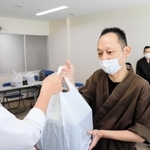 保健所職員に弁当を渡す飲食店主の飯田健二さん＝明石市ゆりのき通１