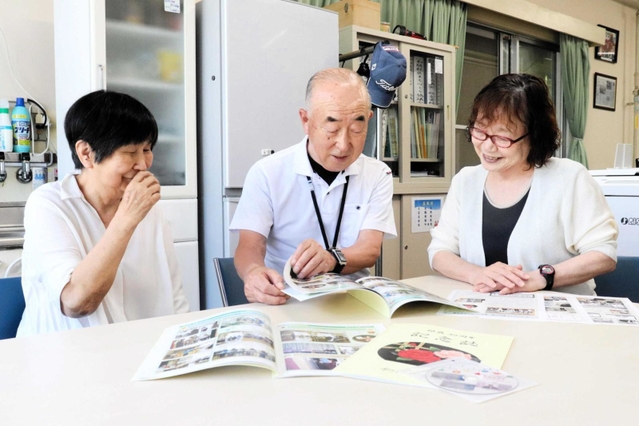 冊子を見ながら３０年を振り返る「和の会」のメンバー＝明石市和坂２