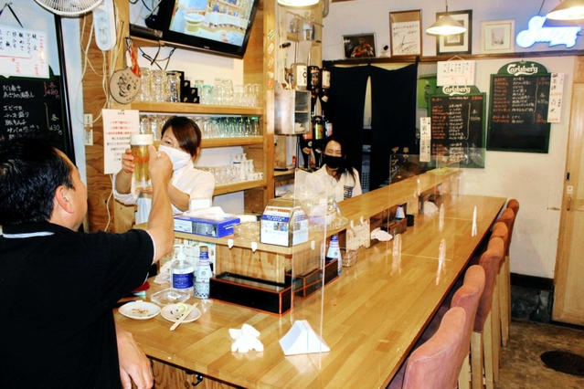 緊急事態宣言が解除され、酒類の提供が解禁となった居酒屋。さっそく常連客が顔を見せた＝明石市内