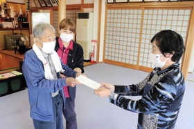 馬田好一さん（左）から寄付金を受け取るボランティア団体のメンバー＝明石市明南町３
