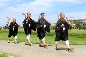 装束に身を包み、豊作を祈って水田を巡る４人の氏子＝明石市魚住町清水