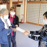 馬田好一さん（左）から寄付金を受け取るボランティア団体のメンバー＝明石市明南町３
