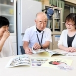 冊子を見ながら３０年を振り返る「和の会」のメンバー＝明石市和坂２