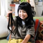 カットした自分の髪を手に持つ有本花糸さん＝明石市