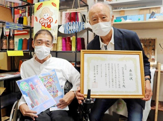 バリアフリー化の促進に貢献し、表彰を受けたＮＰＯ法人「ウィズアス」の鞍本長利代表（右）＝明石市本町１