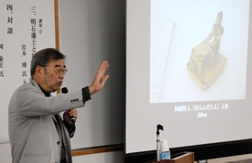 阿蘭陀人人形（右）など明石藩主夫人の副葬品について解説する岡泰正さん＝明石市上ノ丸２