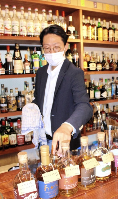 開店準備をする店主兼バーテンダーの林さん＝明石市東仲ノ町