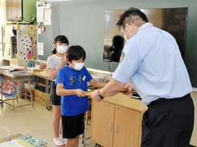 受講１万人を記念し、認定書を贈られる大久保南小の児童＝大久保南小学校（明石市消防本部提供）