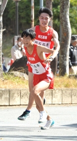 男子・明石高専の１区山本雄大選手（奥）から２区山本大夏選手にたすきが渡る＝西脇市総合市民センター（撮影・笠原次郎）