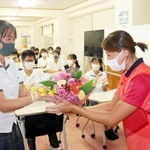 生徒代表から花束を贈られる新沢由貴選手（右）＝明石市二見町西二見