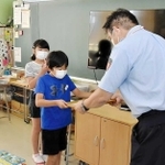 受講１万人を記念し、認定書を贈られる大久保南小の児童＝大久保南小学校（明石市消防本部提供）