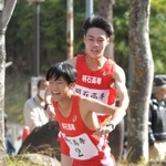 男子・明石高専の１区山本雄大選手（奥）から２区山本大夏選手にたすきが渡る＝西脇市総合市民センター（撮影・笠原次郎）