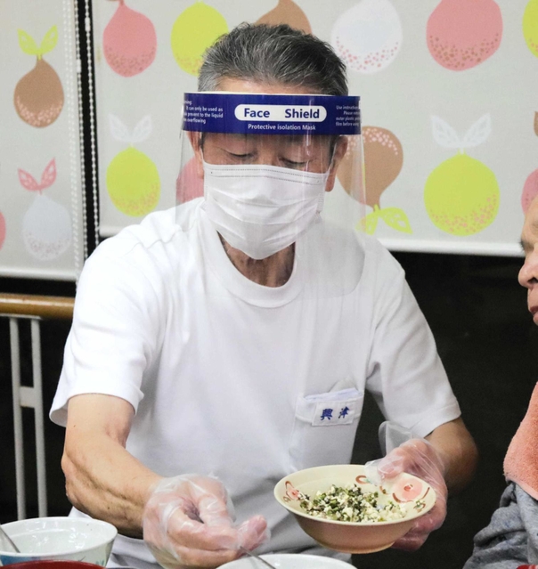利用者の食事の介助をする興津さん＝明石市大久保町大窪