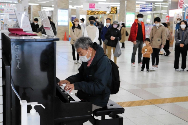明石駅構内に設置されたストリートピアノ。演奏に誘われ、立ち止まる通行人の姿も＝明石市大明石町１