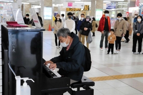 明石駅構内に設置されたストリートピアノ。演奏に誘われ、立ち止まる通行人の姿も＝明石市大明石町１
