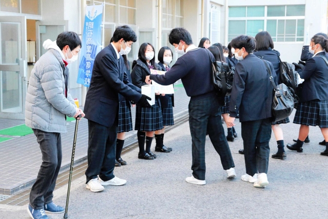 学校玄関前で寄付を呼び掛ける山本育海さん（左）と生徒会役員＝明石市魚住町長坂寺