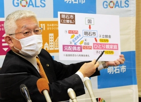 実際の養育者に１０万円が渡るようにする取り組みを説明する泉房穂市長＝明石市役所