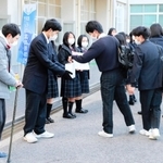 学校玄関前で寄付を呼び掛ける山本育海さん（左）と生徒会役員＝明石市魚住町長坂寺