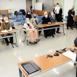旧優生保護法の被害者支援条例案が可決したことについて、泉房穂市長（右）から報告を受ける小林宝二さん（前列左から２人目）、喜美子さん夫妻＝明石市役所
