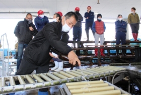 初競り開始直前、魚が運ばれて来るレーンを酒で清める戎本裕明組合長＝明石市岬町