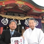 商品サンプルを手にする宮内正次社長（左）と菅谷誠夫宮司＝明石市大蔵本町