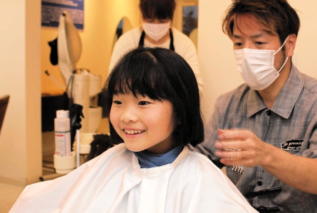 カット後「すっきりした」と笑顔の望心さん＝明石市大久保町江井ヶ島