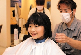 カット後「すっきりした」と笑顔の望心さん＝明石市大久保町江井ヶ島