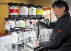 サーバーからパウチパックに生酒を注ぐ渡邉大代表。搾りたての日本酒の味わいを提供する＝明石市本町２