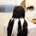 ヘアドネーションに寄付するため髪をカットしてもらう堀江望心さん＝明石市大久保町江井島