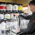 サーバーからパウチパックに生酒を注ぐ渡邉大代表。搾りたての日本酒の味わいを提供する＝明石市本町２
