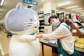 ジュンク堂書店明石店でオリジナルの名刺を手渡すマル（左）＝明石市大明石町１