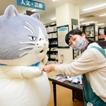 ジュンク堂書店明石店でオリジナルの名刺を手渡すマル（左）＝明石市大明石町１