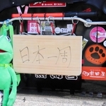 まな板でつくった「日本一周」の看板を掲げて移動する＝明石公園