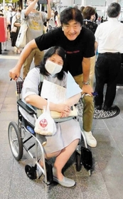 昨年７月、神戸の街で佐渡さん（右）と写真に納まる多久島さん（本人提供）