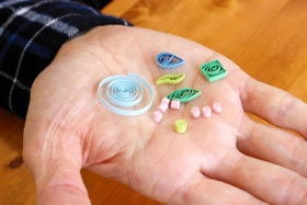 パーツの大きさは１センチ以下。全体のバランスや配色を考えながら接着剤で貼り付ける＝明石市相生町１