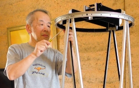 手作りの望遠鏡を組み立てる天文家津村光則さん（明石市立天文科学館提供）