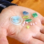 パーツの大きさは１センチ以下。全体のバランスや配色を考えながら接着剤で貼り付ける＝明石市相生町１