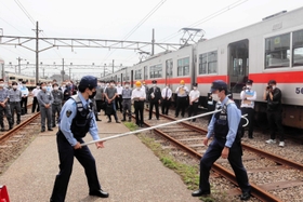 刺股の使い方を説明する警察官ら＝明石市二見町東二見