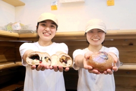 クラウドファンディング限定ベーグルと、考案した赤尾さん（右）、焼き上げる長濱さん＝明石市桜町