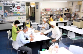 藤江駅前オアシスで打ち合わせする運営ボランティアら＝明石市藤江