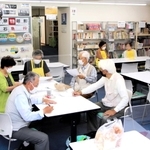 藤江駅前オアシスで打ち合わせする運営ボランティアら＝明石市藤江