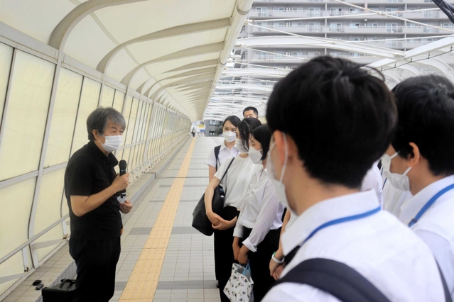 事故があった歩道橋上で明石市の新入職員に話す下村誠治さん＝明石市大蔵海岸通１