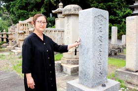歴代藩主の墓が並ぶ長寿院で両親の墓石に手を添える彦山靖子さん＝明石市人丸町